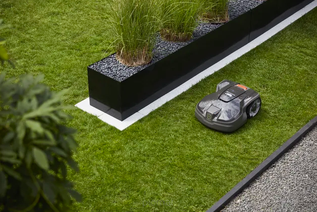 Husqvarna Automower 450X w ogordzie omija przeszkody